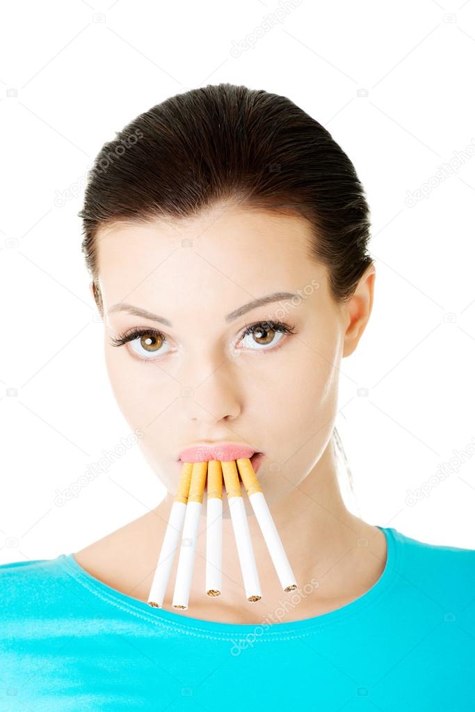 Young beautiful woman with cigarettes in mouth.