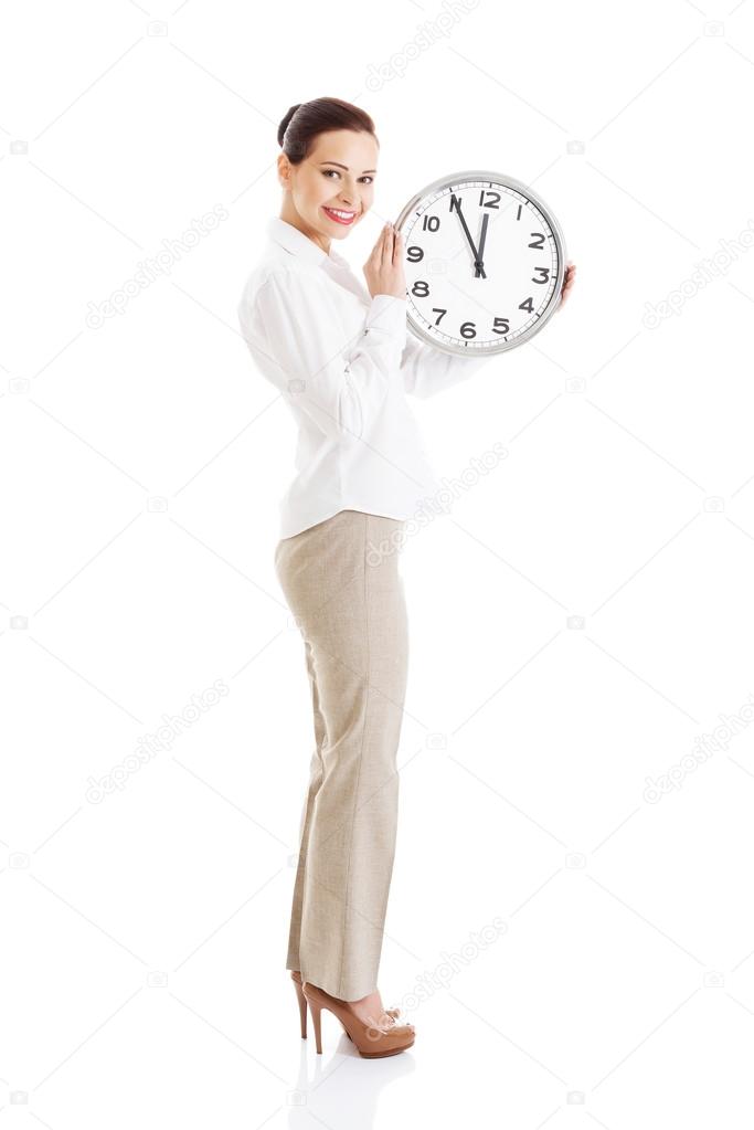 Young beautiful business woman holding clock.