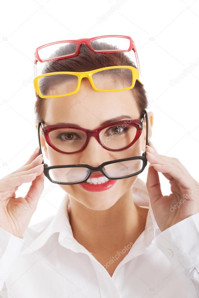 Beautiful woman wearing four different pairs of eyeglasses.