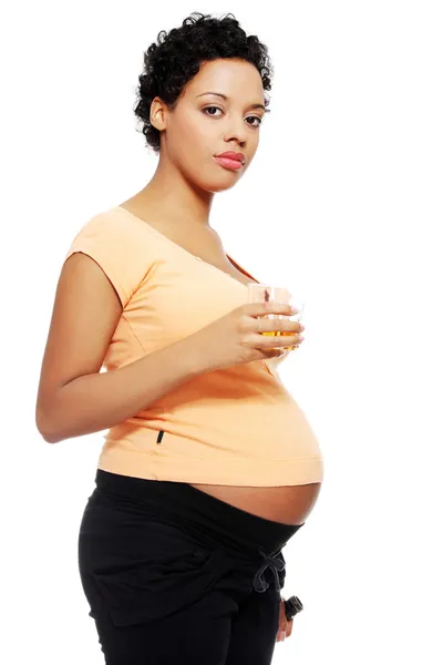 Mujer embarazada sosteniendo un vaso de alcohol junto a su barriga — Foto de Stock