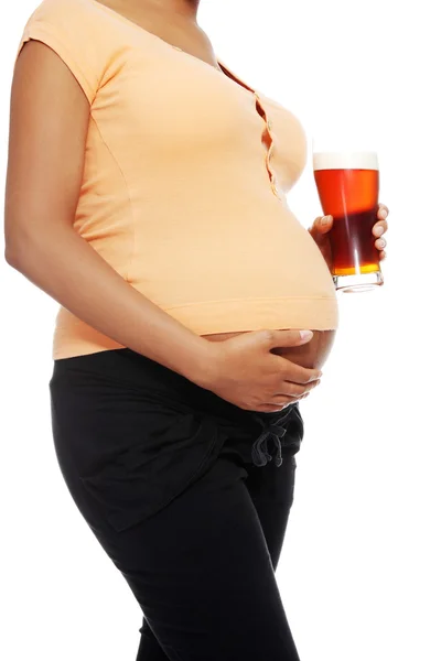 彼女のおなかの横にあるアルコールのガラスを保持している妊娠中の女性 — ストック写真