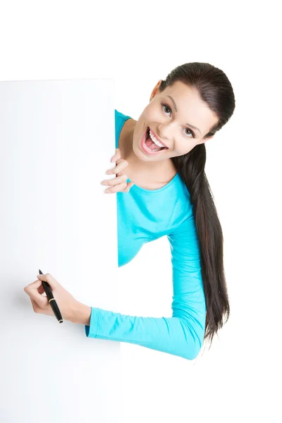 Gelukkige vrouw schrijven met een pen op een leeg bord. — Stockfoto