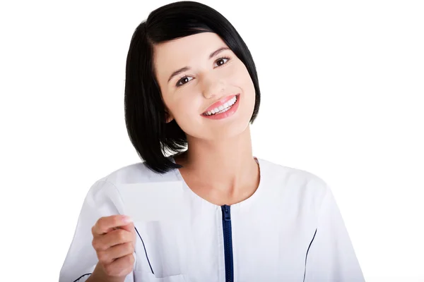 Woman doctor or nurse holding business card — Stock Photo, Image