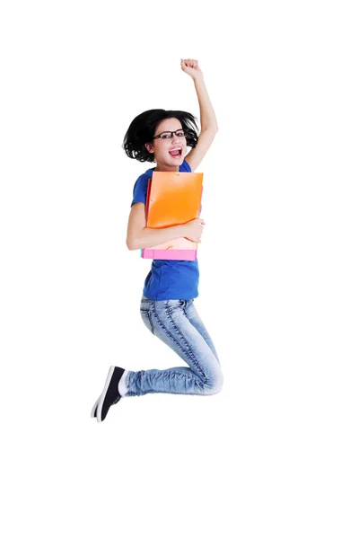 Happy female student jumping with a notebook — Stock Photo, Image