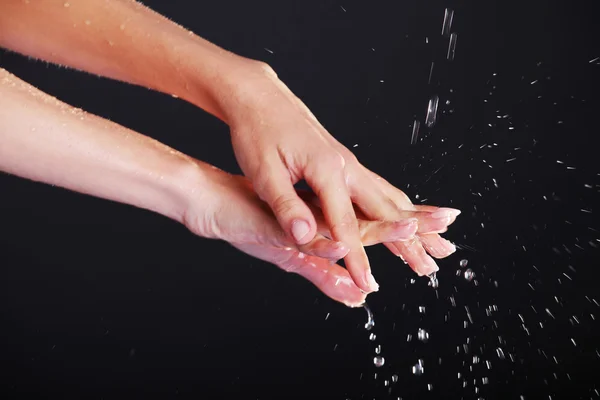 Eau tombant sur les mains féminines — Photo