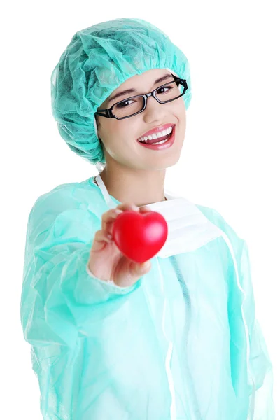 Улыбающаяся женщина-врач или медсестра, держащая сердце — стоковое фото