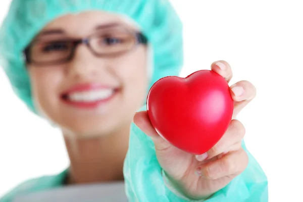 Médica sorridente ou enfermeira segurando o coração — Fotografia de Stock