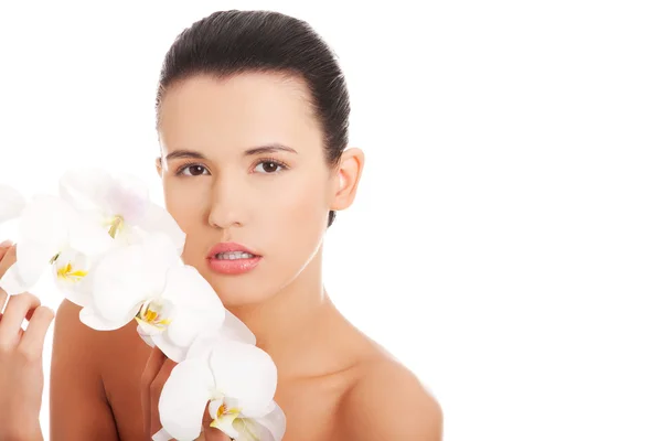 Hermosa joven con flor de orquídea — Foto de Stock