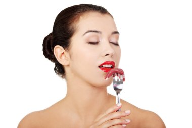 Young beautiful woman eating raw meat.