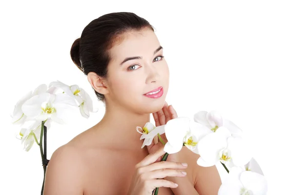 Mulher com pele saudável e com flor de orquídea — Fotografia de Stock