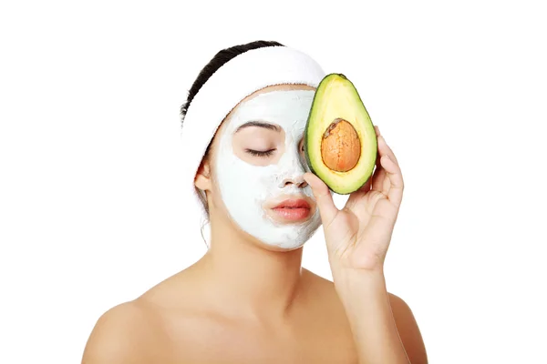 Junge Frau hält Avocado in der Hand — Stockfoto
