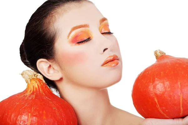 オレンジを持つ女性がカボチャを保持しているをメイクアップします。 — ストック写真