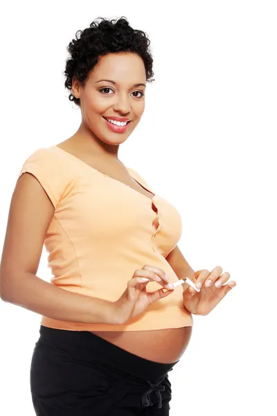 Pregnant woman breaking a cigarette — Stock Photo, Image