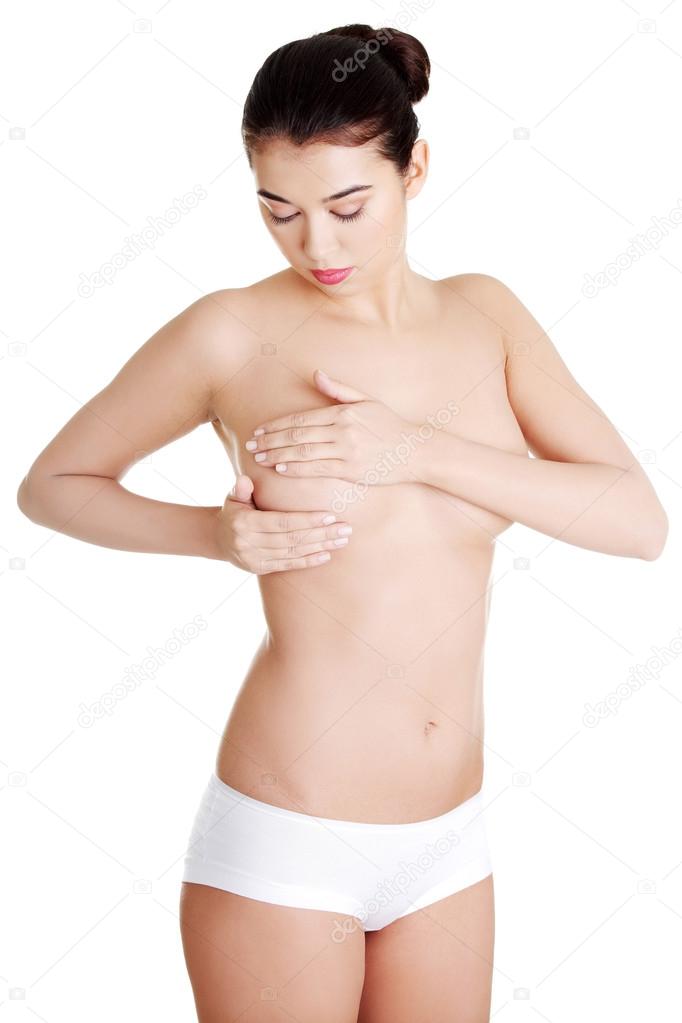 Woman examining breast mastopathy or cancer.