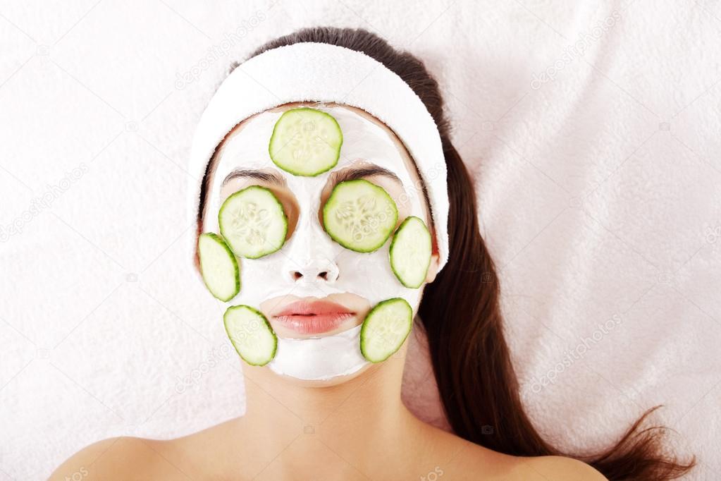 Young woman with cucumber slices on the face