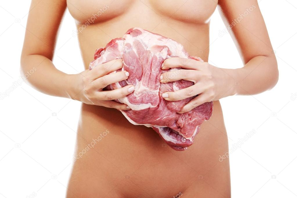 Nude woman holding big part of raw meat (pork neck).