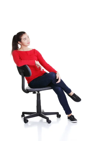 Молода щаслива жінка сидить на кріслі — стокове фото