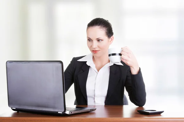 Mooie brunette zakenvrouw die op laptop werkt — Stockfoto