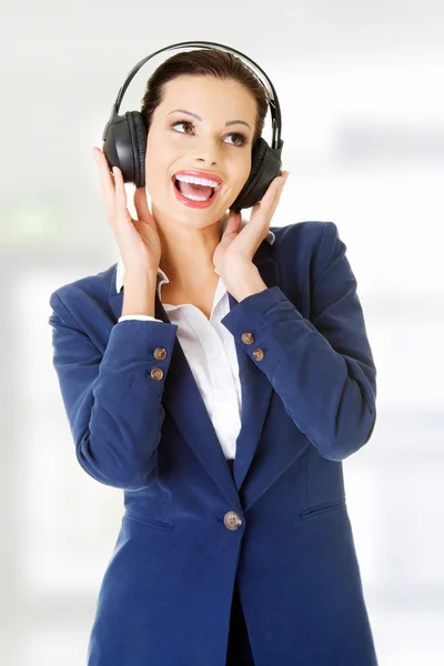 Empresaria escuchando la música a través de auriculares — Foto de Stock