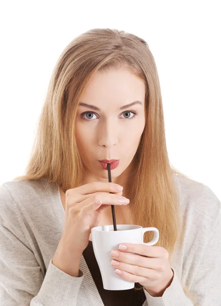 Hermosa mujer está bebiendo de una taza con paja . — Foto de Stock