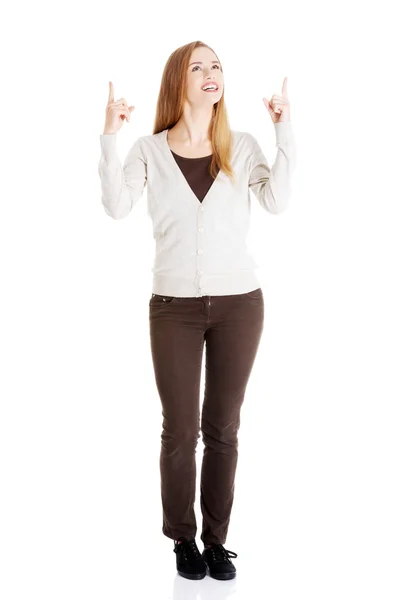 Hermosa mujer casual está apuntando hacia arriba y la publicidad . — Foto de Stock