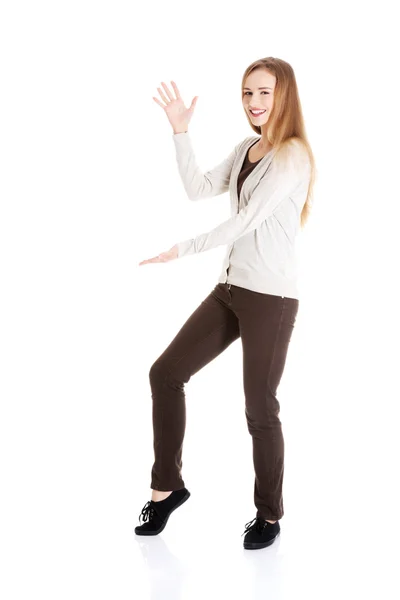 Vacker casual kvinna poserar med hennes hand upp och ben. — Stockfoto