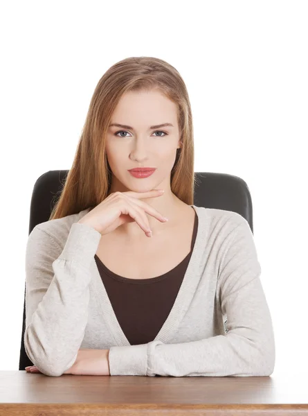 Beautiful casual woman sitting by a desk. — Stock Photo, Image