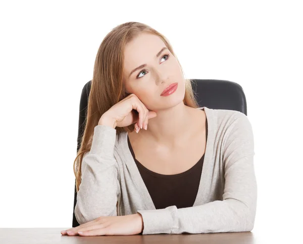 Beautiful casual woman sitting by a desk and day- dreaming. — Stock Photo, Image