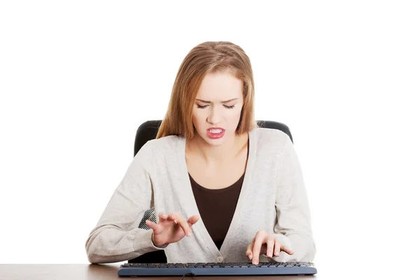 Schöne lässige Frau, die vor Wut auf die Tastatur schreibt. — Stockfoto