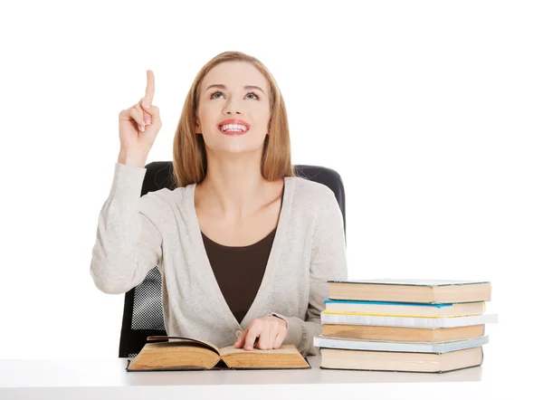 Student vrouw zitten door stapel boeken — Stockfoto