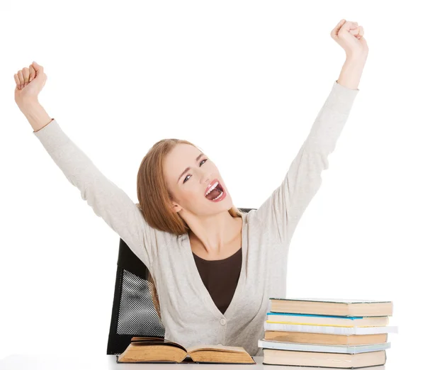 Glückliche Studentin mit erhobenen Händen und einem Stapel Bücher. — Stockfoto