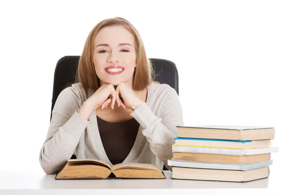 Mulher estudante bonita sentada ao lado da mesa com livros — Fotografia de Stock