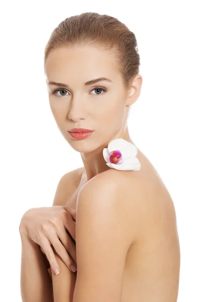 Naakt naakte vrouw met witte bloem op schouders. — Stockfoto