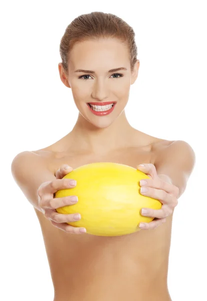 Hermosa mujer caucásica desnuda sostiene melón fresco amarillo . — Foto de Stock