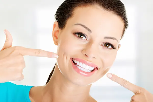 Frau zeigt ihre perfekten Zähne. Stockfoto