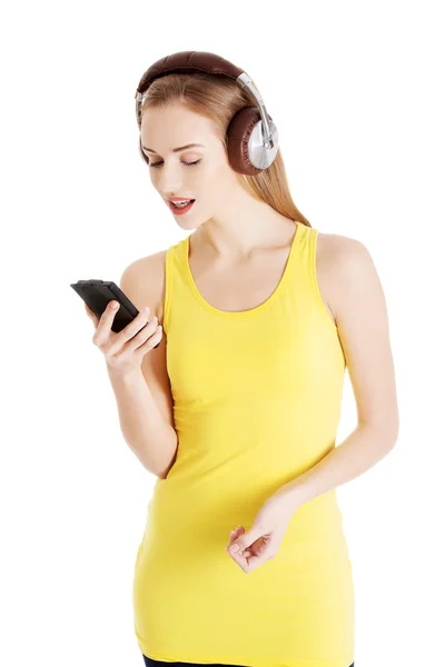 Ung vacker kvinna lyssnar på musik med hörlurar. — Stockfoto