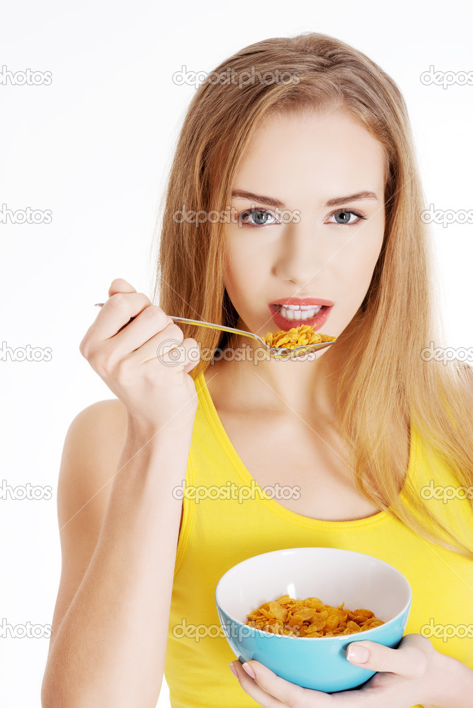 Beautiful caucasian woman eating cereals.