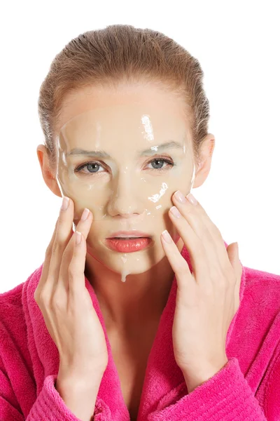 Hermosa mujer en albornoz rosa y máscara facial havinf . — Foto de Stock