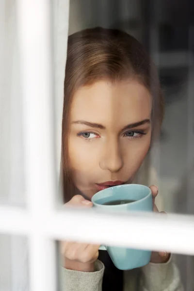Schöne kaukasische Frau trinkt heißen Kaffee oder Tee. — Stockfoto