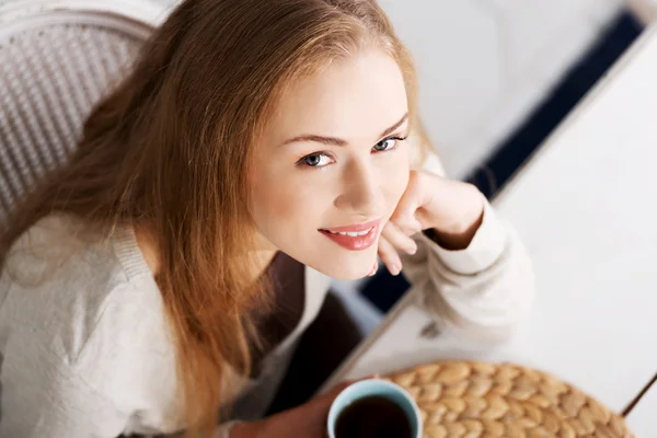 Schöne kaukasische Frau sitzt an einem Tisch mit schwarzem Kaffee. — Stockfoto