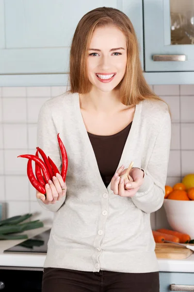 Mooie Kaukasische vrouw houdt chili peppers en knoflook. — Stockfoto