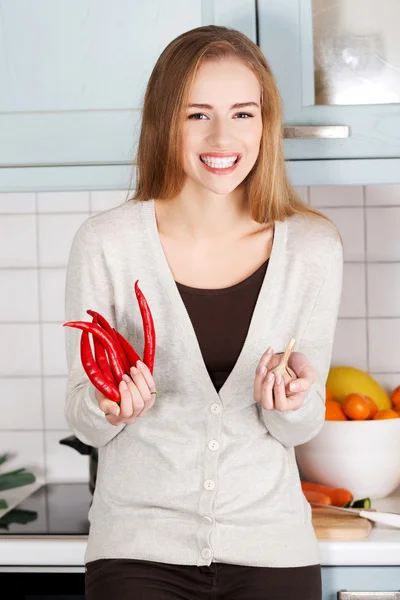 Mooie Kaukasische vrouw houdt chili peppers en knoflook. — Stockfoto