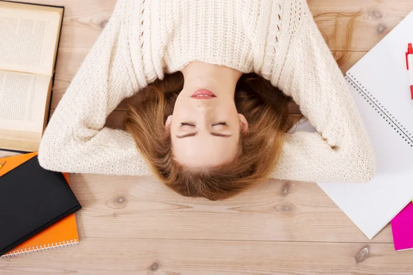 轻松的年轻学生女人躺在地板上 — 图库照片