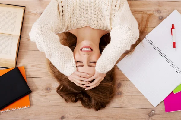 Mladá krásná žena ležící na podlaze s knihami. — Stock fotografie