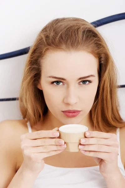 Mulher branca bonita em lingerie branca está bebendo café pequeno — Fotografia de Stock