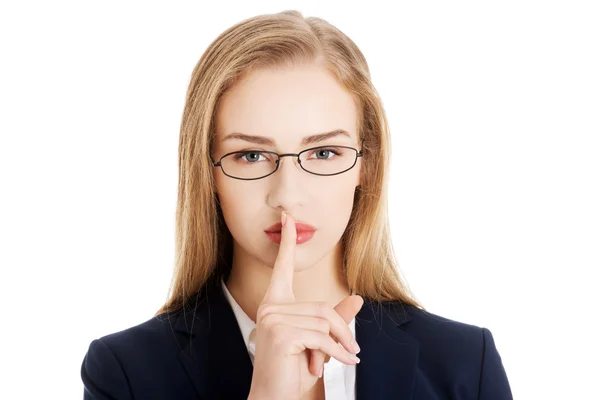 Beautiful business woman with finger on lips. — Stock Photo, Image