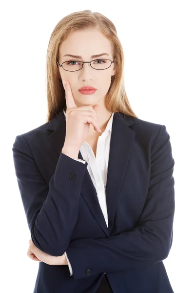 Hermosa mujer de negocios en gafas con el dedo en la mejilla . — Foto de Stock