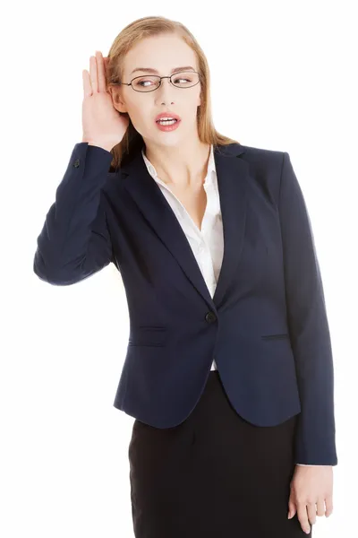 Beautiful business woman is over-hearing, touching her ear. — Stock Photo, Image