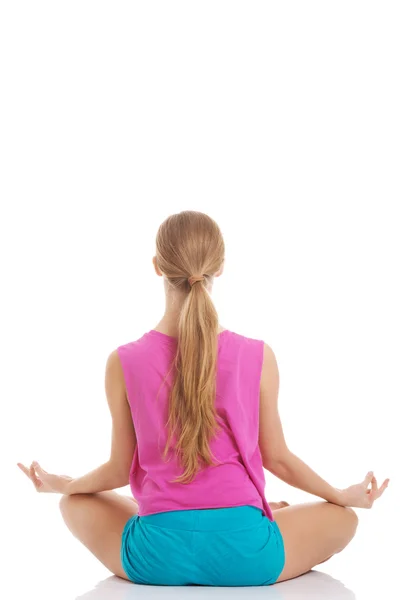 Hermosa joven caucásica mujer está haciendo ejercicio, haciendo yoga . —  Fotos de Stock