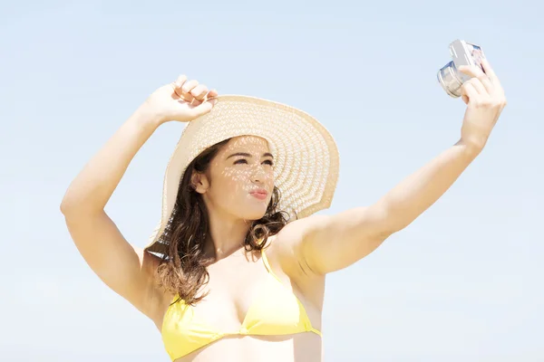 Hermosa mujer joven en un sombrero y traje de baño sobre el fondo de la playa —  Fotos de Stock